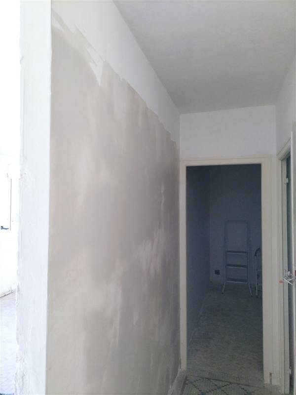 Couloir aux murs enduits et poncés, prêts pour la sous-couche