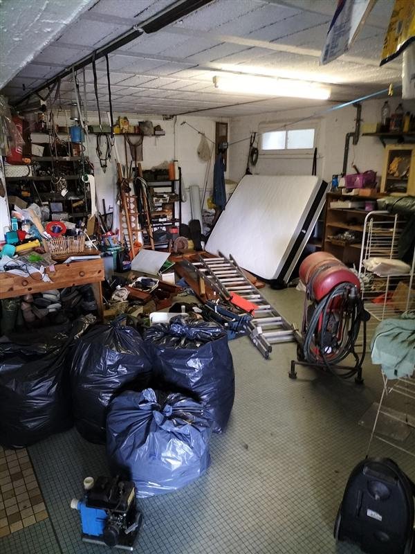 Garage rempli de sacs, de cartons et d'objets avant débarras
