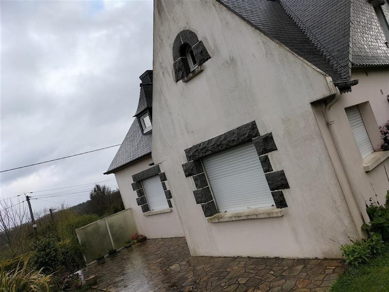 Maison néo-bretonne aux murs grisés et verdis, entourages de fenêtres en granit