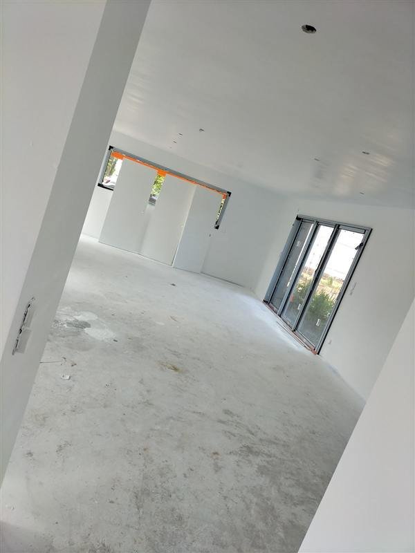 Grand séjour lumineux aux murs et plafond repeints en blanc
